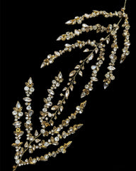 A delicate headpiece featuring silver crystals and rhinestones, arranged in a floral pattern.