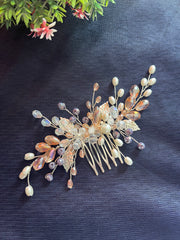 Decorative hair comb with beads and leaves on a dark fabric background