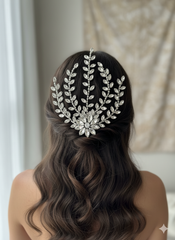 Woman with wavy hair wearing a decorative headpiece against a neutral background