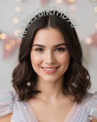 Woman wearing a sparkling tiara with 'Happy Birthday' text against a blurred background