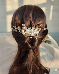 Hair with a decorative hairpiece featuring pearls and beads against a neutral background