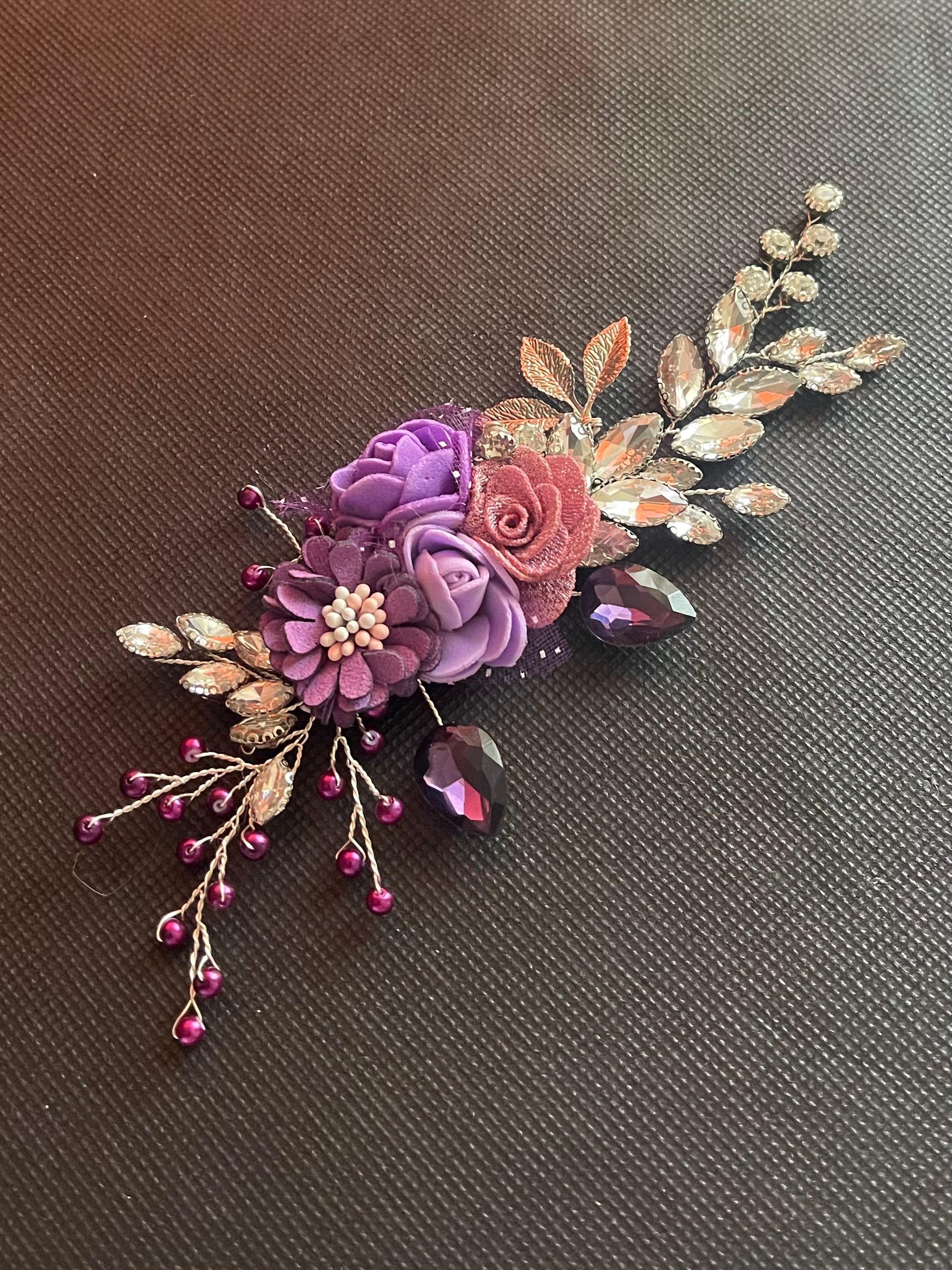 Decorative floral hair clip with purple and pink flowers on a brown background