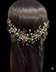 Hairpiece with gold and pearl embellishments on a dark background