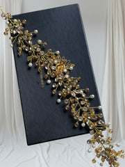 Gold and pearl hair vine on a black box with 'Vilhelm' branding against a white curtain background