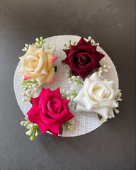 Decorative wreath with red, white, and pink roses on a gray background
