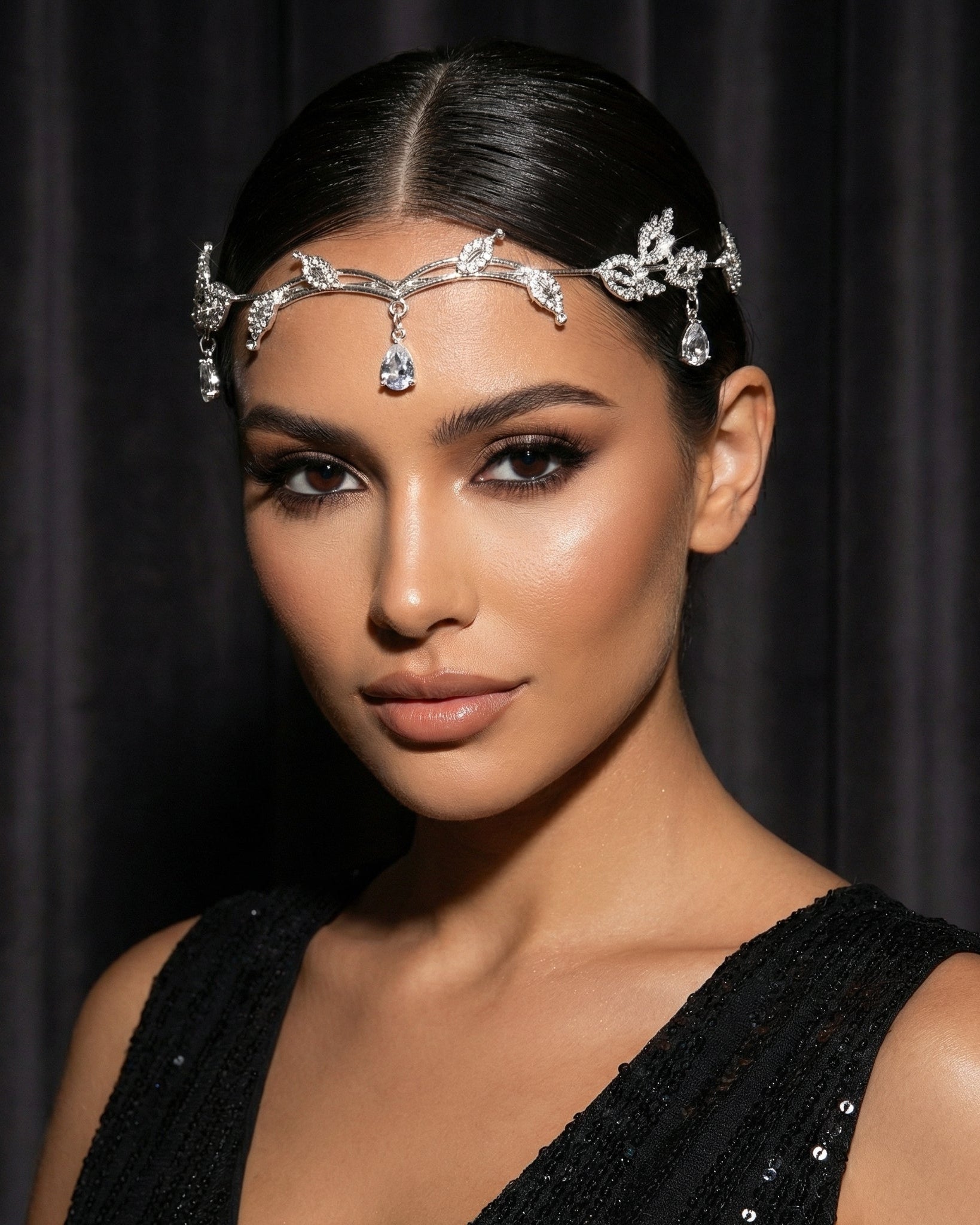 Woman wearing a decorative headpiece against a black background